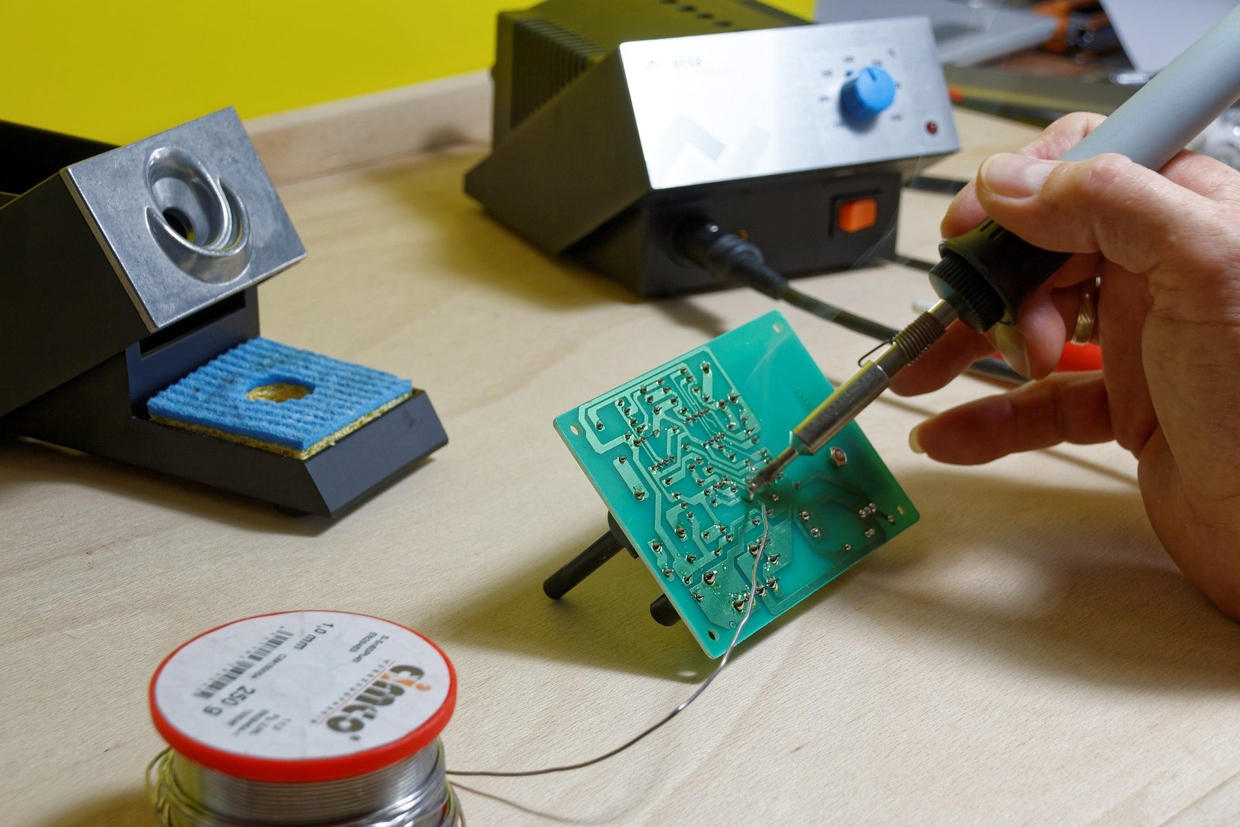 A person soldering a circuit board 