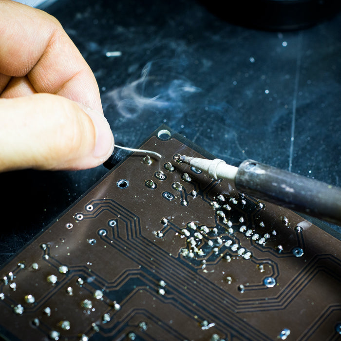 Image of a person soldering a circuit board