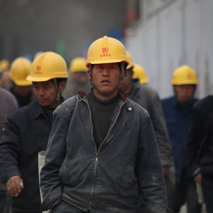 A group of industrial workers in grey jackets 